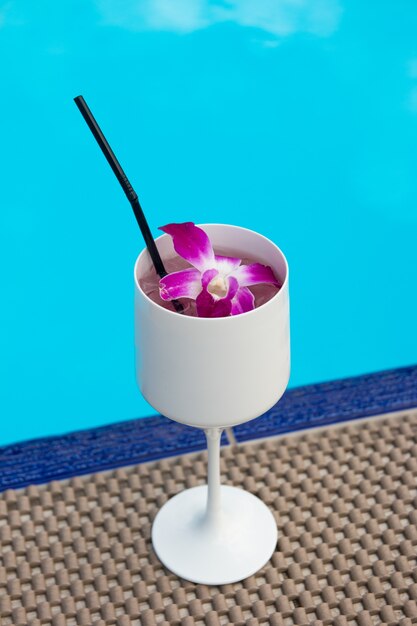 Um copo branco com uma bebida no fundo da piscina. Bebida não alcoólica de praia no resort