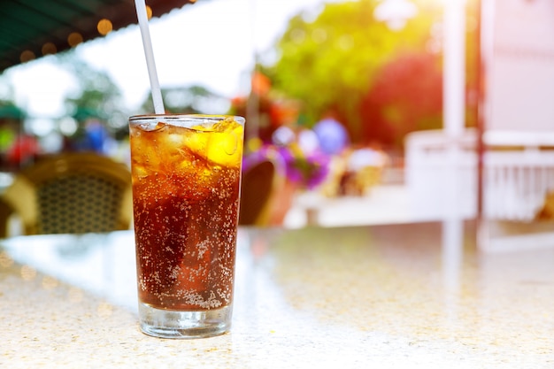 Um copo contendo uma bebida alcoólica em uma mesa de um terraço de um bar