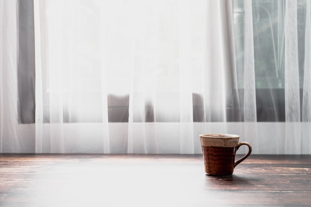 Um copo de água e uma caneca de café estão na mesa.