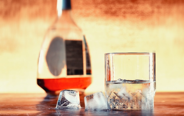 Um copo de álcool com gelo em um balcão de bar. Uísque com refrigerante em um copo. Publicidade de bebida alcoólica.