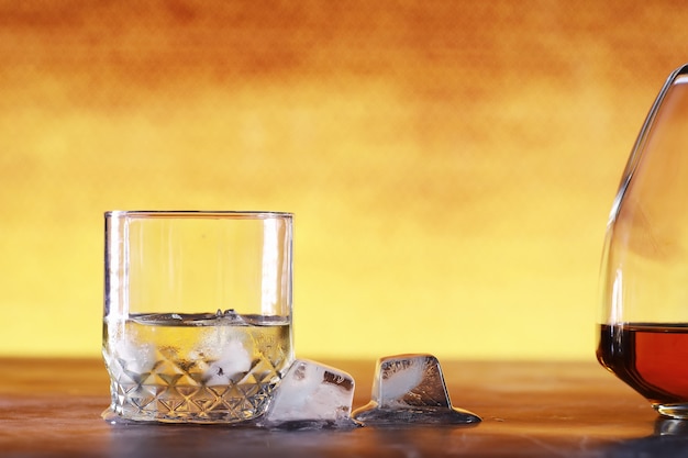 Um copo de álcool com gelo em um balcão de bar. Uísque com refrigerante em um copo. Publicidade de bebida alcoólica.