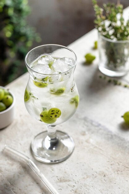 Foto um copo de bebida refrescante de desintoxicação gelada com groselha e tomilho infusão de água ou coquetel de bagas