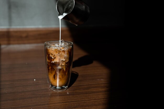 Um copo de café com leite na mesa.