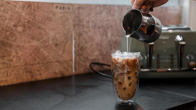 Um copo de café com leite na mesa.