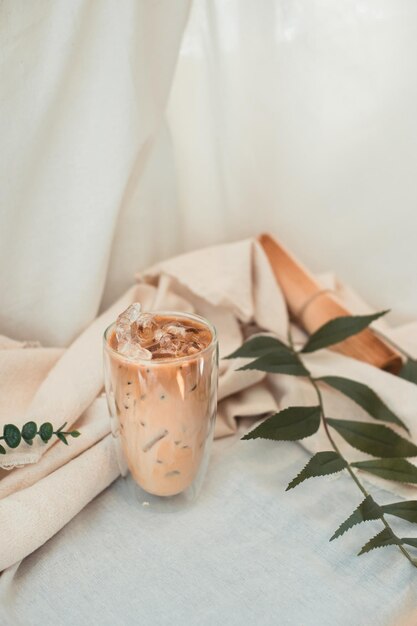 Um copo de café gelado com leite na mesa.