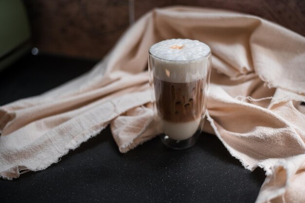 Um copo de café gelado com leite na mesa.