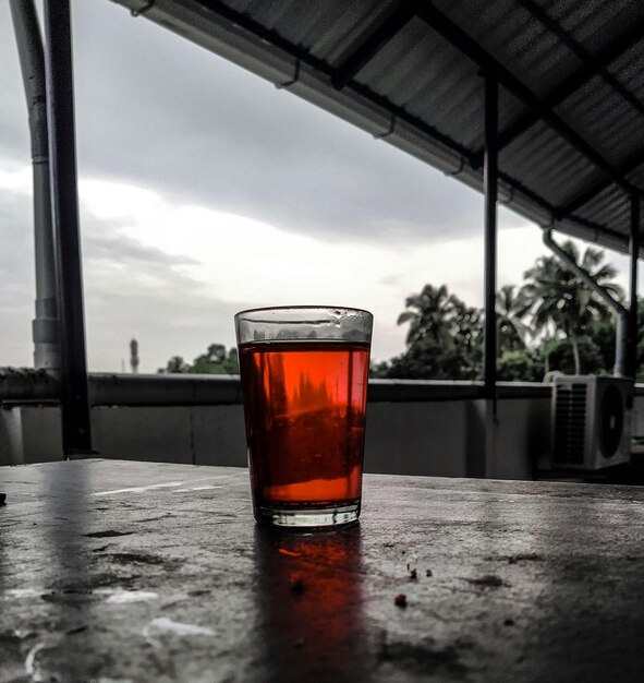 um copo de cerveja em uma mesa com um líquido vermelho nele