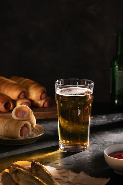 Um copo de cerveja light, dois peixes secos, linguiça na massa e molho