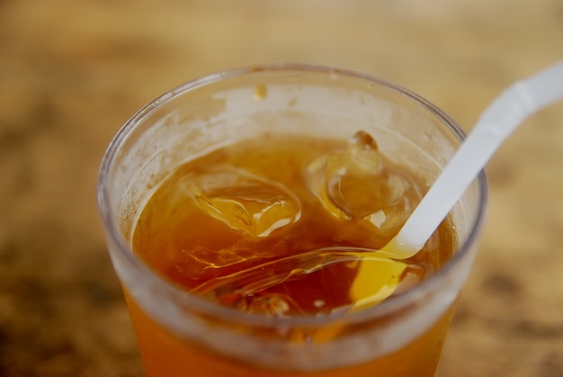 um copo de chá gelado em uma mesa de madeira