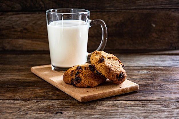 Um copo de leite e biscoitos de aveia na mesa da cozinha. O café da manhã é leve.