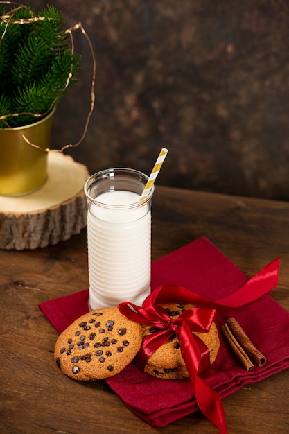 Um copo de leite e biscoitos para o papai noel Natal deleite para o papai noel foto vertical