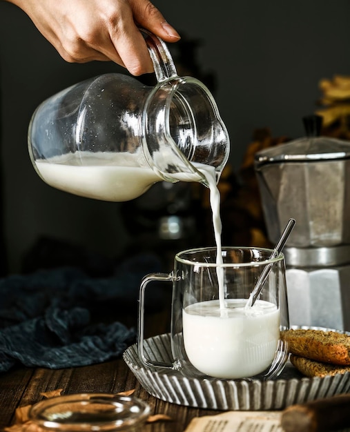 Um copo de leite está sendo derramado em um copo Como preparar café com leite