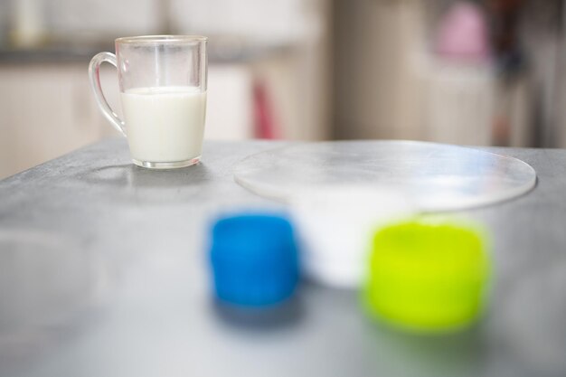 Um copo de leite na mesa de um cozinheiro preparando bolos