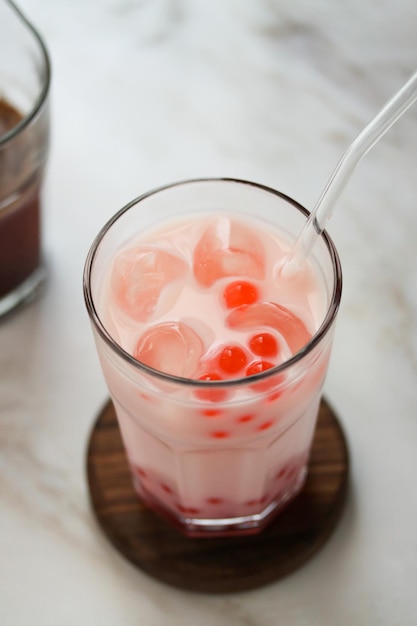 Um copo de milk-shake de framboesa vermelha com um canudo.