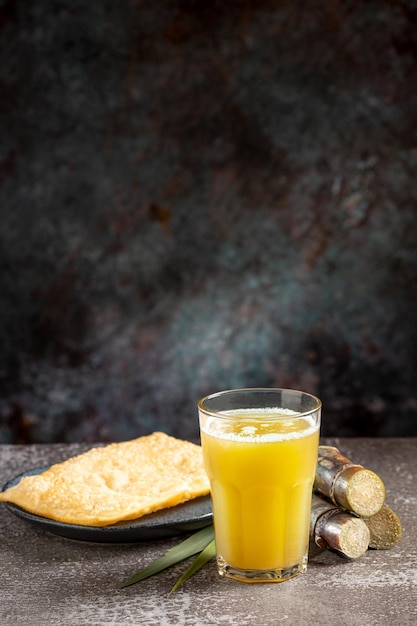 Um copo de suco de cana-de-açúcar com doces fritos um lanche típico do brasil