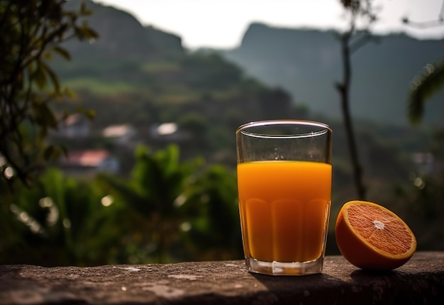 Um copo de suco de laranja fica em uma borda com vista para as montanhas ao fundo