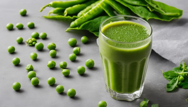 Foto um copo de sumo verde com ervilhas na mesa.