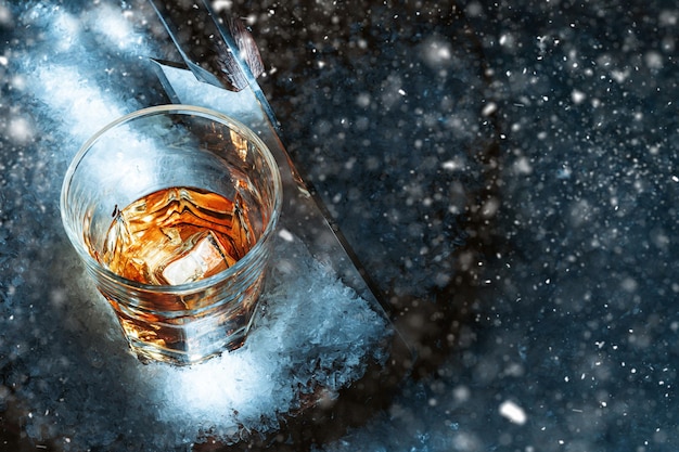 Foto um copo de uísque no conceito de neve de uma bebida quente em uma noite fria de inverno
