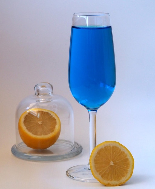 Um copo de vinho azul e um limão amarelo