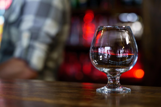 um copo de vinho fica em cima da mesa no café no fundo de um garçom e interior