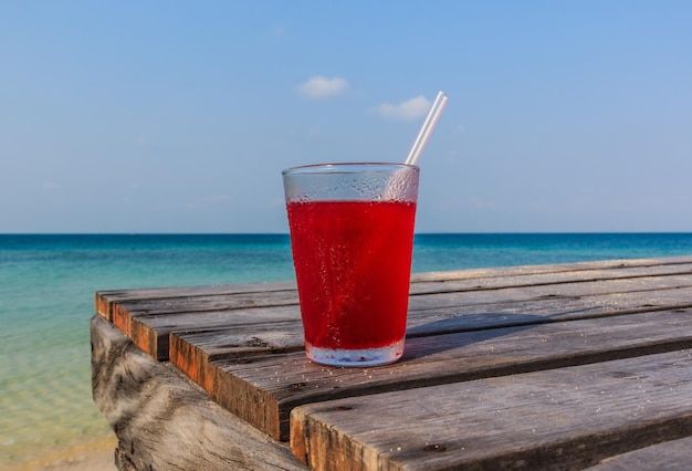 Foto um copo de vinho tinto na praia contra o céu