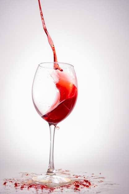 Foto um copo de vinho vermelho com salpicos em branco