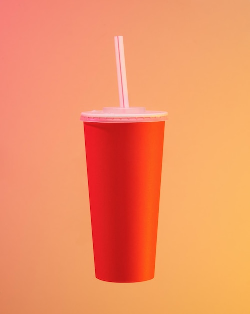 Um copo vermelho com uma palha Bebidas e prazer