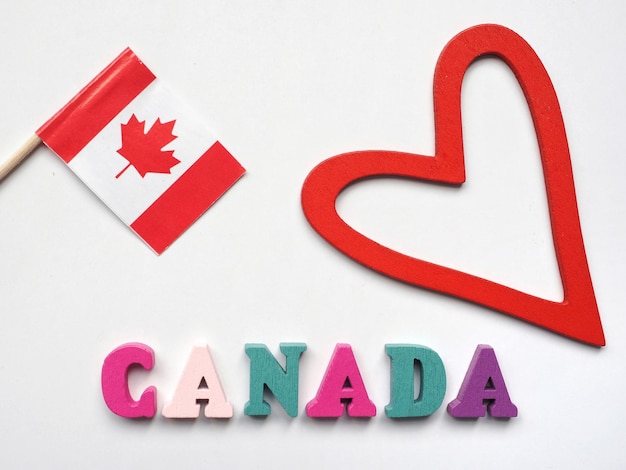 Um coração vermelho e uma bandeira canadense Próximo ao topo da palavra canadá