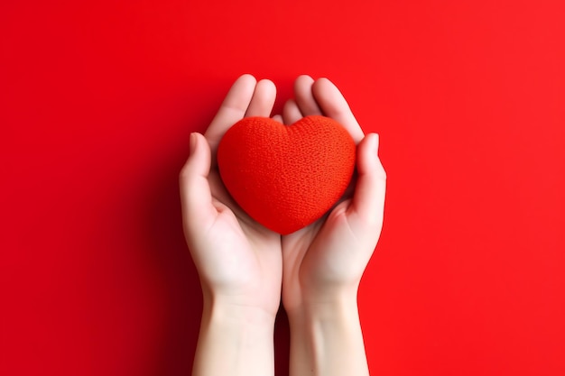 Um coração vermelho nas mãos de uma pessoa