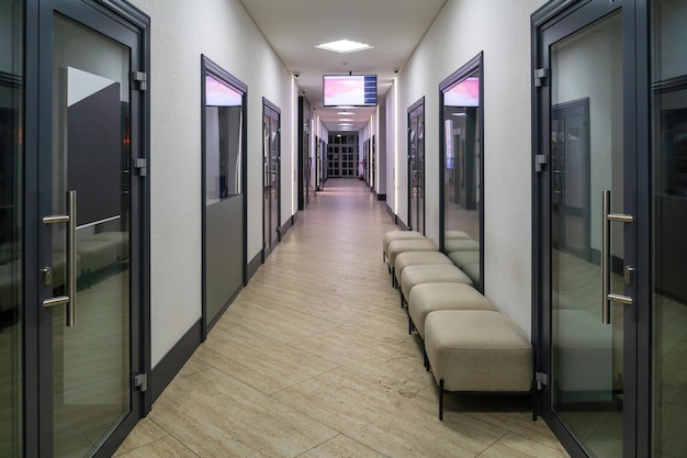 Um corredor em um prédio de escritórios do tipo urbano Interior moderno do saguão de um prédio de escritórios com portas de vidro e paredes brancas limpas Um longo corredor iluminado em um centro de negócios moderno
