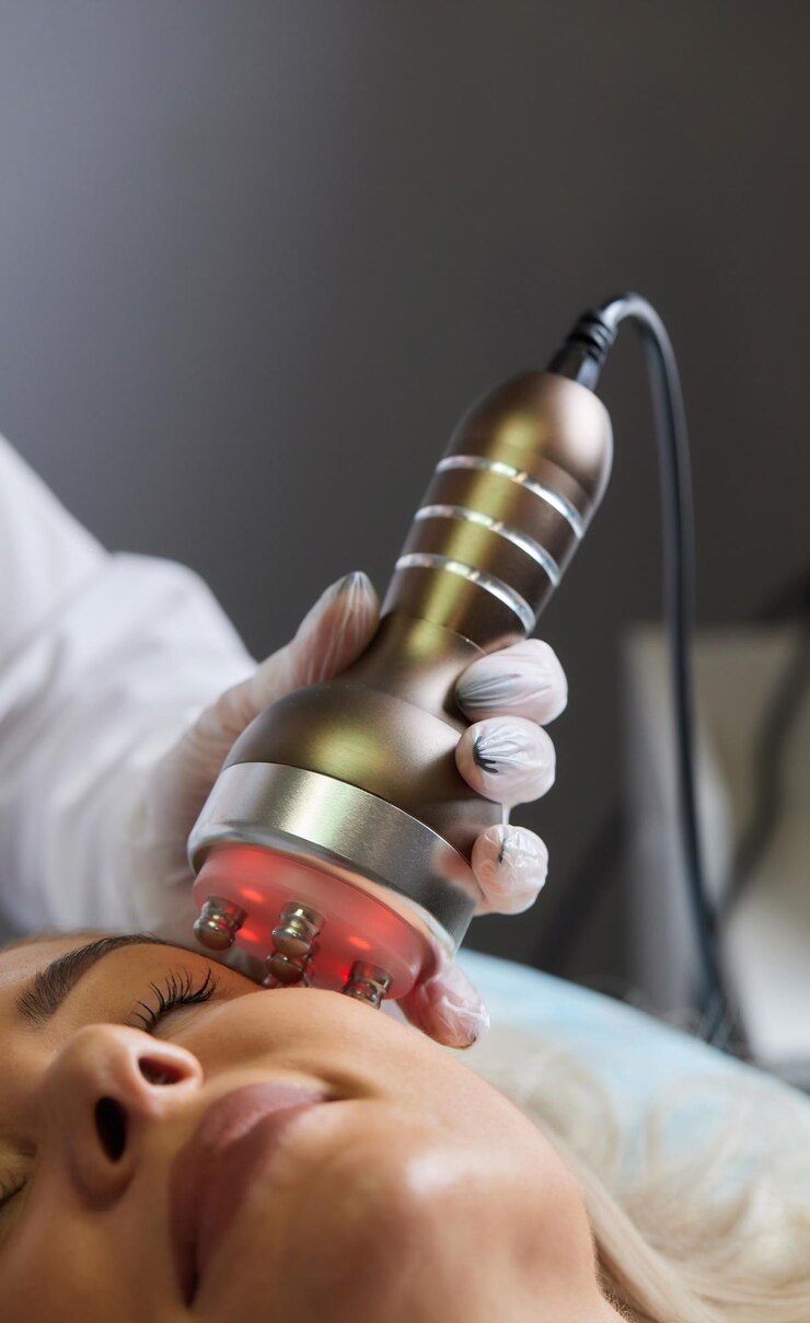 Foto um cosmetologista em luvas de borracha faz o procedimento de rflifting no rosto no fundo, o dispositivo de cosmetologia rf close up vista lateral o conceito de cosmetologia profissional e rejuvenescimento