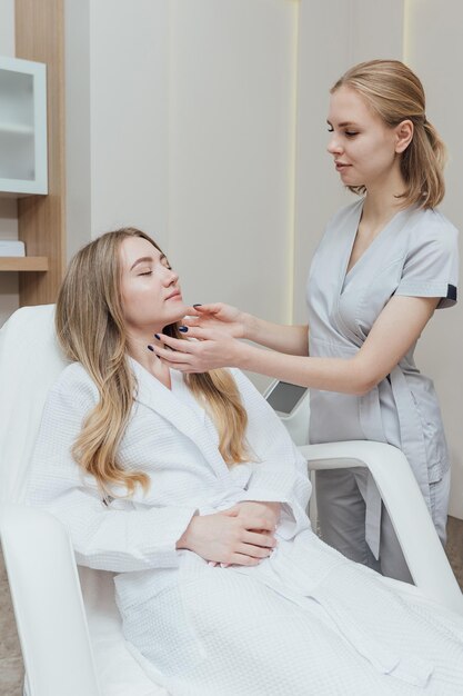 Um cosmetologista especialista realiza uma análise da pele facial do paciente