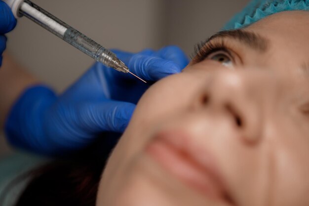 Foto um cosmetologista injeta uma seringa em um paciente