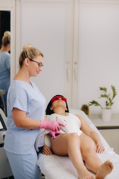 Um cosmetologista realiza um procedimento de depilação a laser no escritório