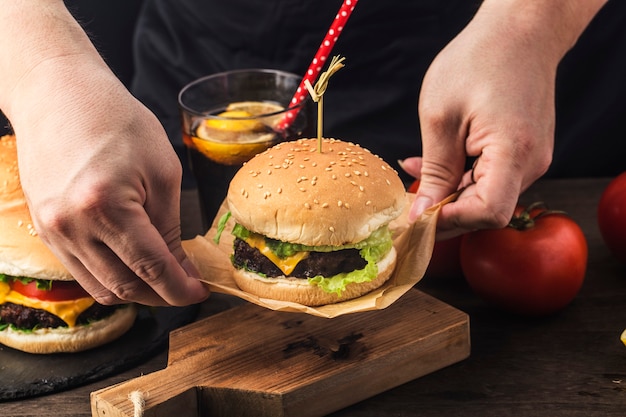 Um cozinheiro segura um delicioso hambúrguer de carne acabado de fazer