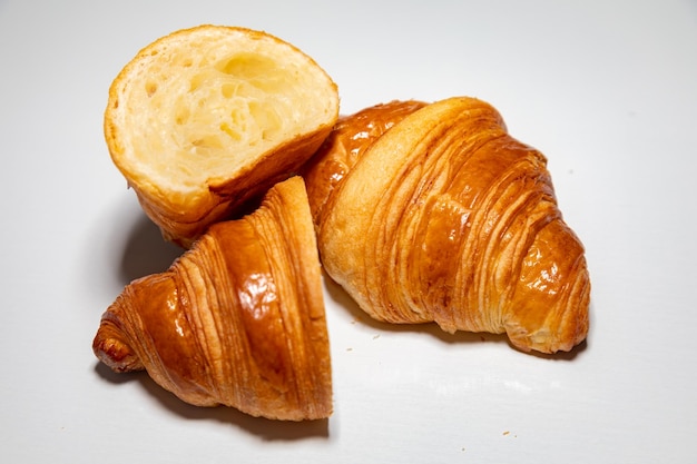 Um croissant com uma crosta crocante está em um prato branco.