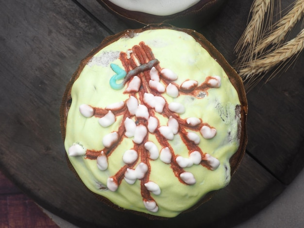 Um cupcake com cobertura verde e confeitos brancos e vermelhos.