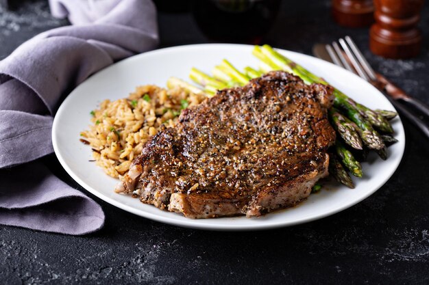 Um delicioso bife com arroz e espargos.