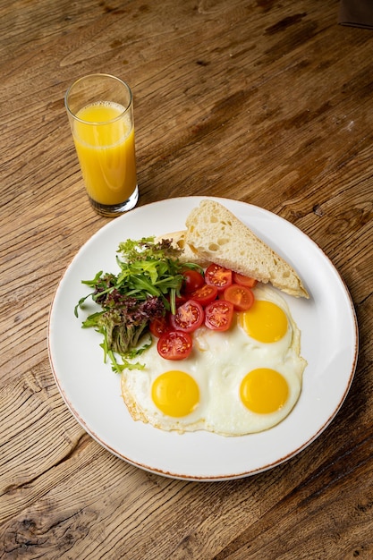 um delicioso café da manhã em um prato preparado no restaurante. Ovos fritos com tomate e salada