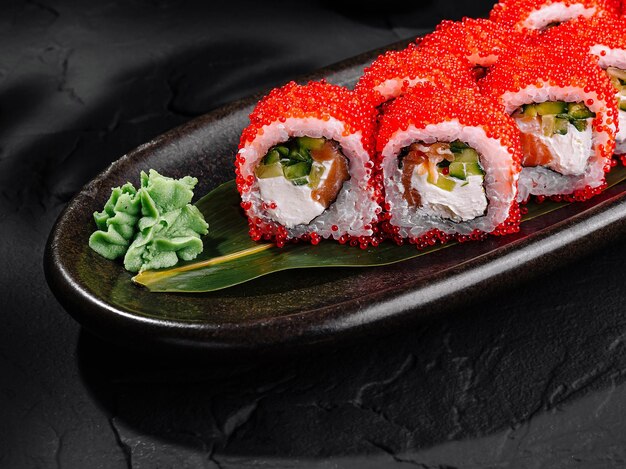 Um delicioso rolo de sushi de caviar vermelho num elegante prato escuro.