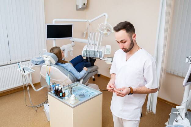 Um dentista profissional se comunica com uma paciente. Consultório odontológico para exame do paciente. Discussão do processo de tratamento dentário.