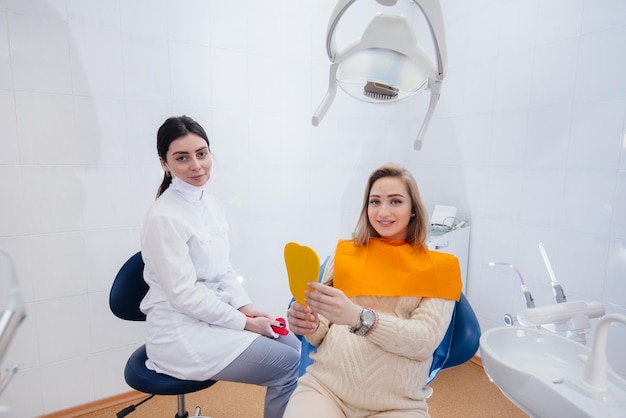 Um dentista profissional trata e examina a cavidade oral de uma grávida em um consultório odontológico moderno. Odontologia.