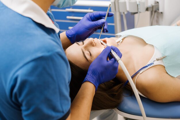 Um dentista trabalhando com paciente com broca odontológica