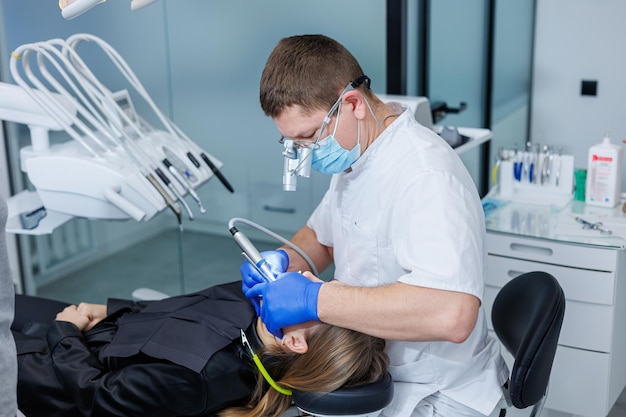 Foto um dentista trata os dentes de um paciente odontologia progressiva moderna consultório odontológico com ferramentas