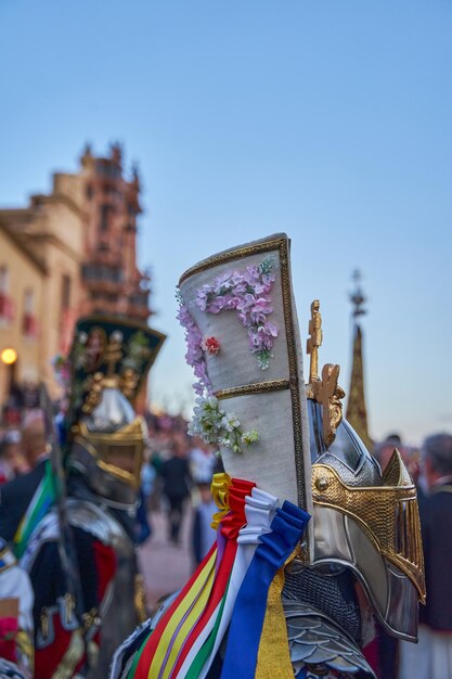 Foto um desfile com uma bandeira e uma bandeira com uma fita rosa que diz 'san miguel de allende '