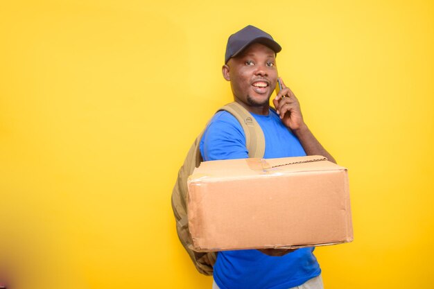 Um despachante africano com mochila fazendo uma chamada carregando