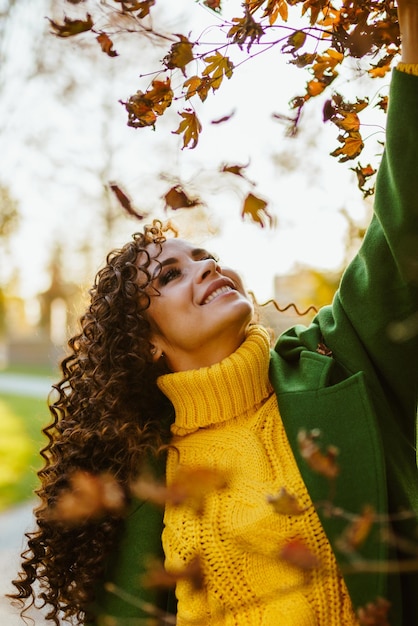 Foto um dia brilhante e ensolarado no parque de outono uma bela morena com um sorriso lindo