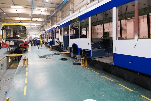 Um dia útil de fabricação de ônibus automático moderno com trabalhadores de carros inacabados em linha de montagem de automóveis de fundo automotivo uniforme protetor