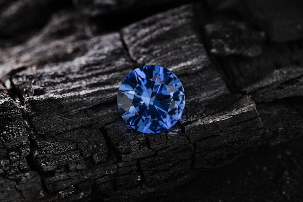 Um diamante azul fica em um pedaço de madeira.