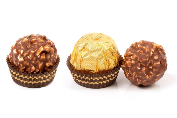 Foto um doce redondo em um pacote de ouro e um doce desembrulhado derramado com chocolate e migalhas de waffle